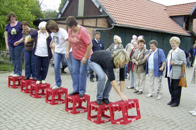 Die Mitglieder des Frauenchors Harmonie bewegen sich auf leeren Cola-Kisten vorwärts. 